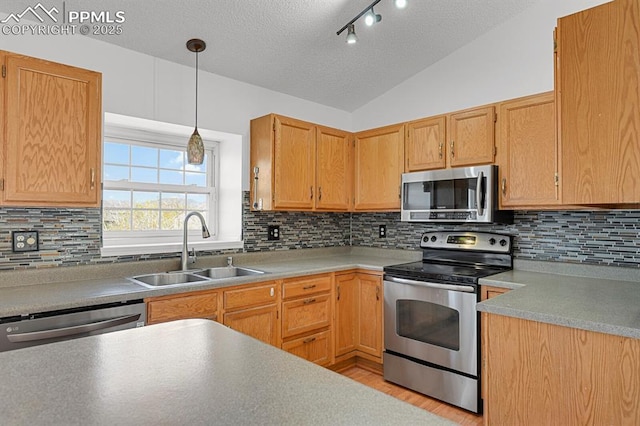 3925 Zurich Dr, Colorado Springs, CO 80920 - kitchen featuring stainless steel appliances, a sink, a textured ceiling, decorative light fixtures, and lofted ceiling