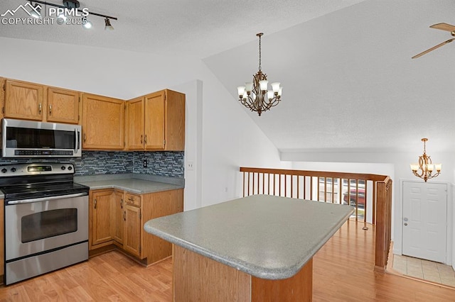 3925 Zurich Dr, Colorado Springs, CO 80920 - kitchen featuring stainless steel appliances, a chandelier, vaulted ceiling, light wood-style floors, and backsplash
