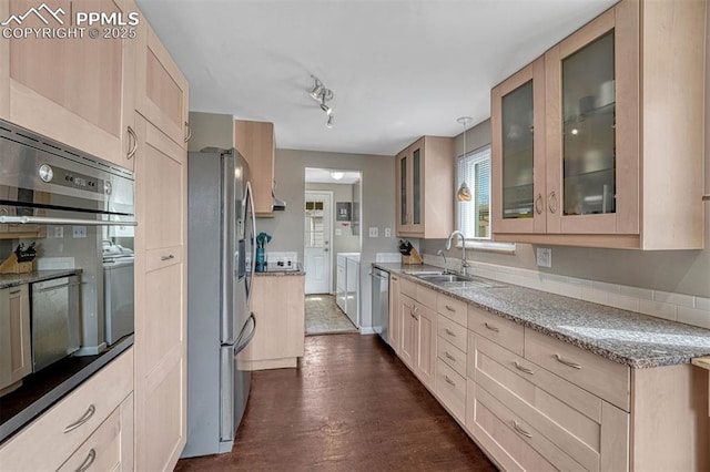 5477 E Asbury Ave, Denver, CO 80222 - kitchen with stainless steel appliances, light stone countertops, separate washer and dryer, a sink, and glass insert cabinets