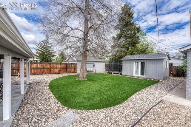 5477 E Asbury Ave, Denver, CO 80222 - view of yard with a trampoline, an outbuilding, and a patio