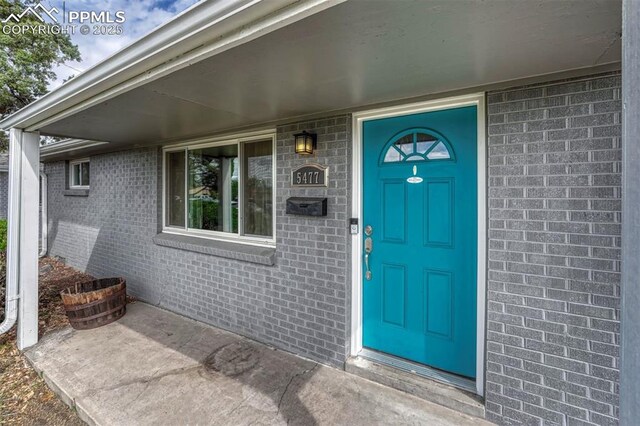 5477 E Asbury Ave, Denver, CO 80222 - doorway to property featuring brick siding