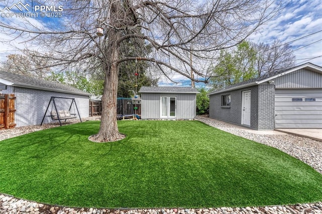 5477 E Asbury Ave, Denver, CO 80222 - view of yard with an outdoor structure, a trampoline, and a garage