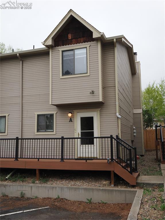 back of house featuring a deck and uncovered parking