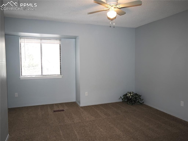 carpeted spare room featuring a ceiling fan, visible vents, a textured ceiling, and baseboards