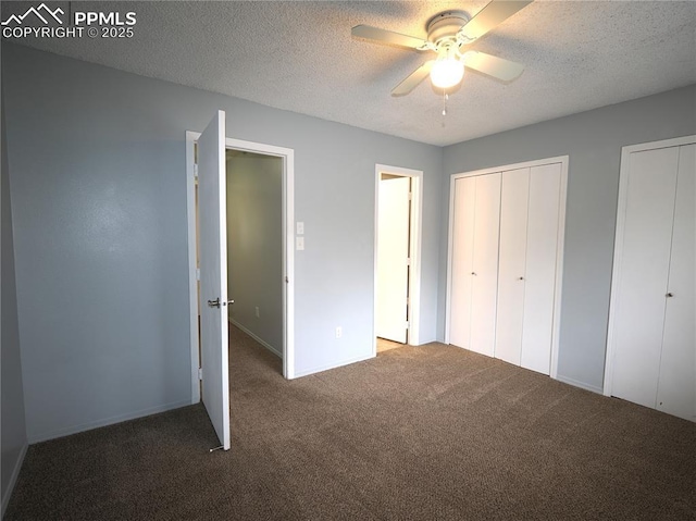 unfurnished bedroom featuring two closets, carpet, ceiling fan, baseboards, and a textured ceiling