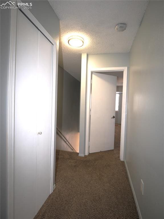 hall with a textured ceiling and carpet