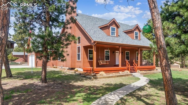 view of front of home featuring roof with shingles, a chimney, a porch, and a front yard
