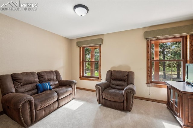 living room with baseboards, plenty of natural light, and light carpet