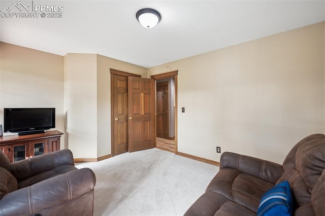 living area featuring carpet flooring and baseboards