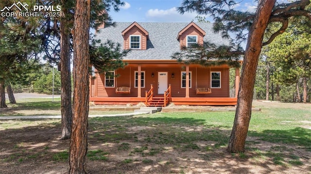 view of front of home featuring a shingled roof, a front lawn, and covered porch