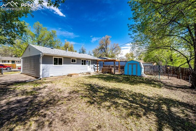 2222 Frontier Dr, Colorado Springs, CO 80911 - back of house featuring a fenced backyard, a storage unit, and an outbuilding