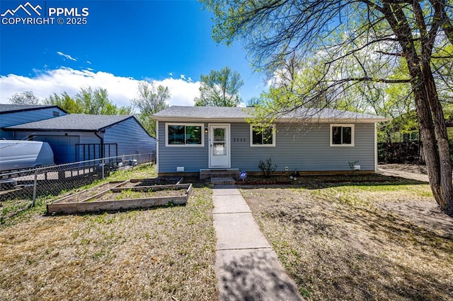 2222 Frontier Dr, Colorado Springs, CO 80911 - view of front facade featuring fence, a vegetable garden, and a front yard
