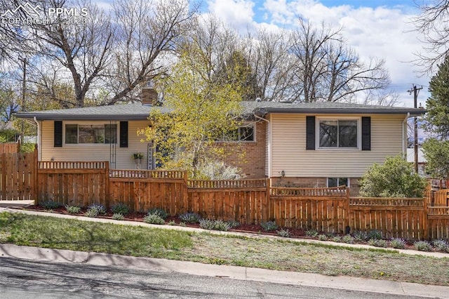 single story home featuring a fenced front yard and a chimney