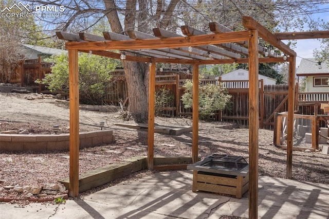 view of patio featuring a fenced backyard, a fire pit, and a pergola