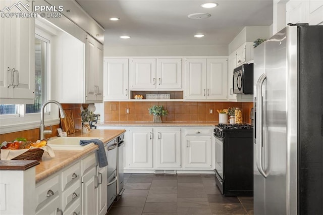 kitchen with tasteful backsplash, light countertops, white cabinets, stainless steel appliances, and recessed lighting
