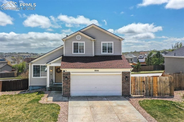 view of front of home featuring brick siding, driveway, a front yard, and fence