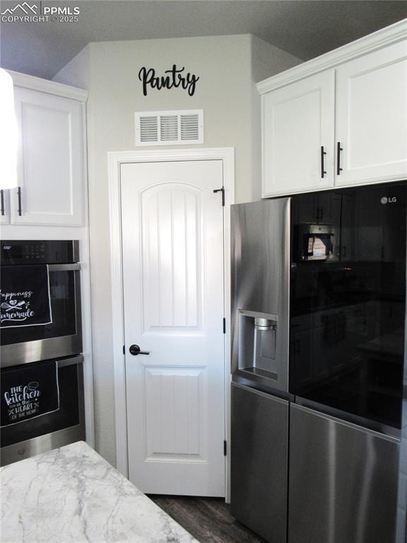 8766 Beaverhead Cir, Colorado Springs, CO 80908 - kitchen featuring stainless steel appliances, white cabinetry, light stone counters, and dark wood-style flooring