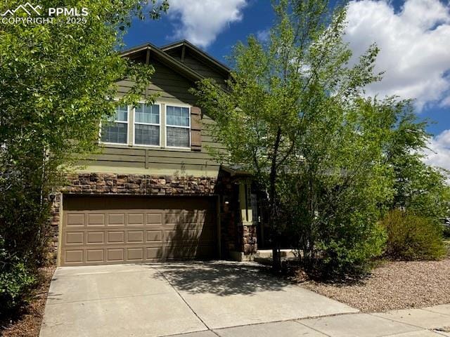 2790 Winterbourne St, Colorado Springs, CO 80910 - view of front facade with stone siding, a garage, and driveway