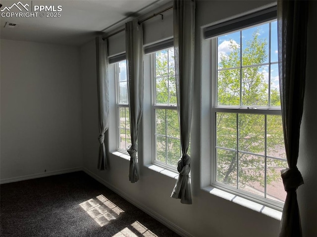 2790 Winterbourne St, Colorado Springs, CO 80910 - empty room featuring healthy amount of natural light, baseboards, and dark colored carpet