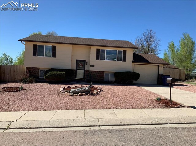 6905 Chippewa Rd, Colorado Springs, CO 80915 - raised ranch featuring a garage, concrete driveway, and brick siding