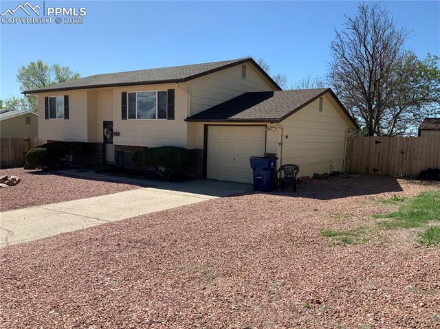 6905 Chippewa Rd, Colorado Springs, CO 80915 - view of front of home with driveway, a garage, brick siding, and a shingled roof