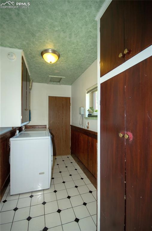 laundry area with laundry area, attic access, light floors, washer / clothes dryer, and a textured ceiling