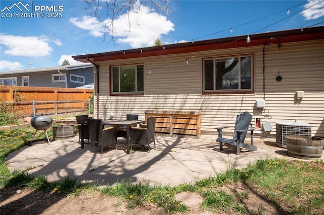 rear view of house featuring a patio, fence, and cooling unit