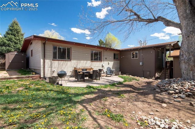 rear view of house with a storage shed, an outbuilding, and a patio area