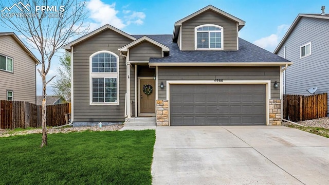 traditional home with fence, roof with shingles, concrete driveway, and a front lawn
