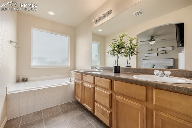 bathroom with visible vents, a sink, a bath, and double vanity