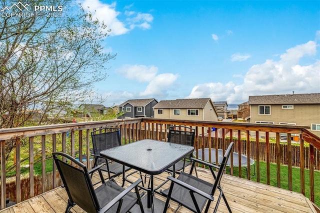 wooden deck featuring fence, a residential view, and outdoor dining space