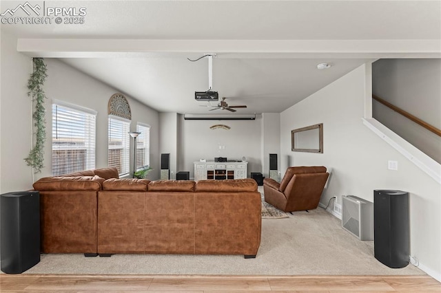 living area with light wood-style floors, ceiling fan, and stairs
