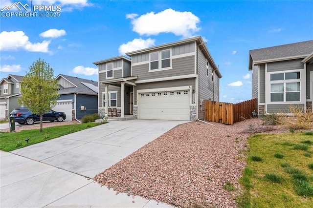 view of front of property featuring fence, stone siding, a garage, board and batten siding, and concrete driveway