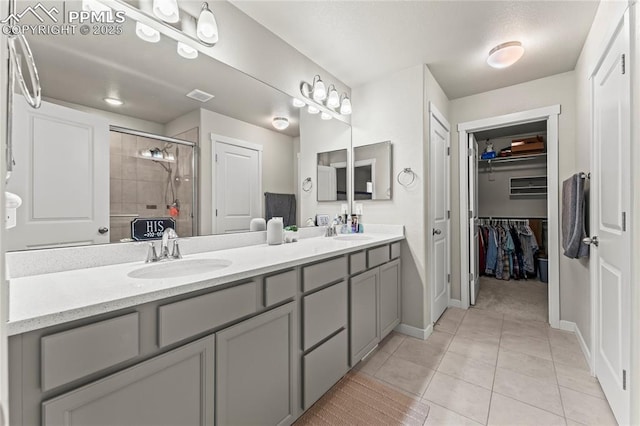 bathroom with double vanity, baseboards, a sink, and a stall shower