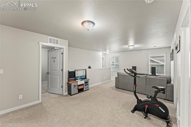 workout area with carpet flooring, a textured ceiling, visible vents, and baseboards