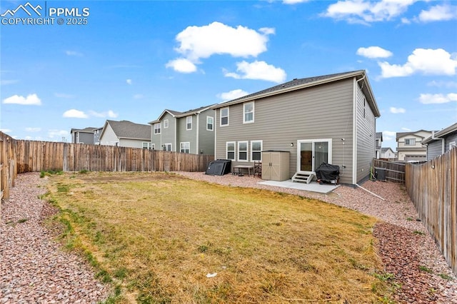 back of property with a residential view, entry steps, a fenced backyard, a patio area, and a yard