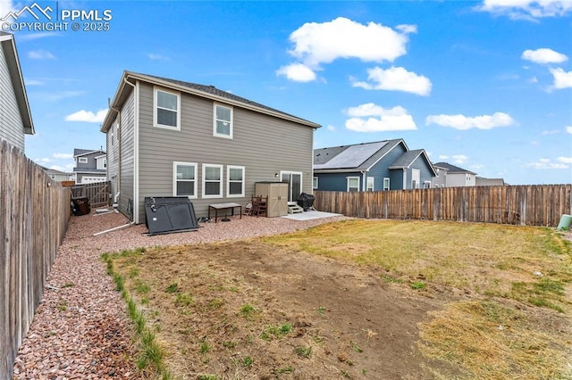 rear view of property with a fenced backyard, a lawn, and a patio area