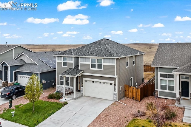 traditional-style home featuring a garage, fence, driveway, and stone siding