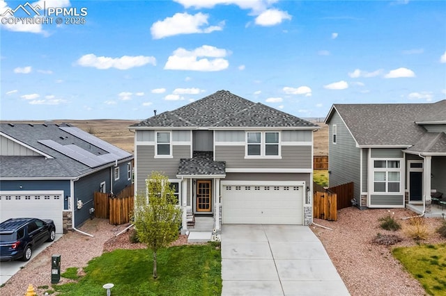 traditional-style house with fence, board and batten siding, driveway, and a garage