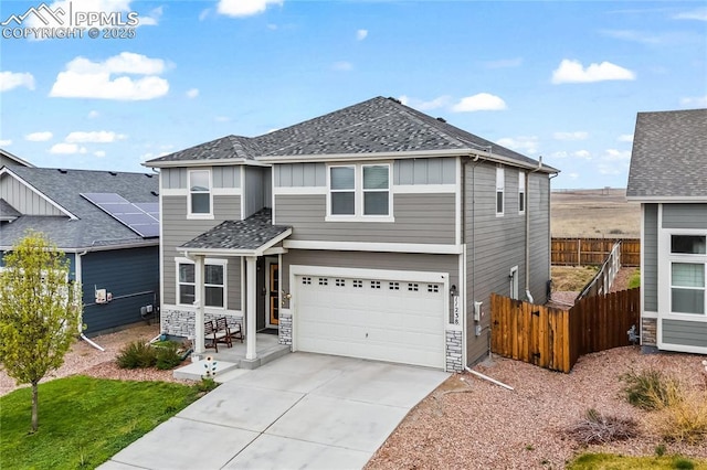 view of front of house with fence, an attached garage, a shingled roof, board and batten siding, and concrete driveway