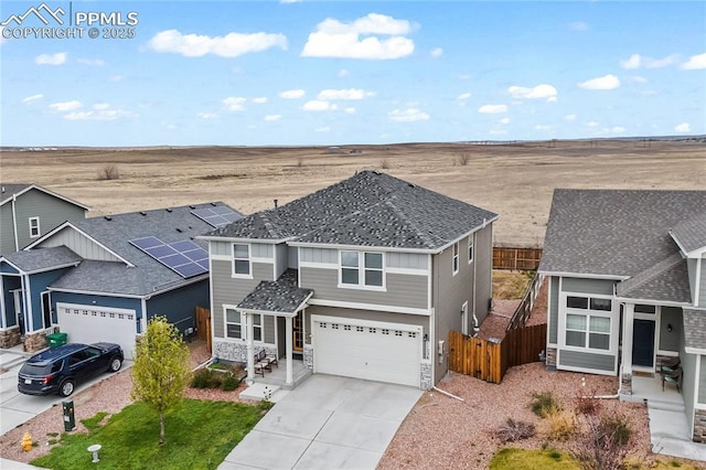 traditional-style home featuring fence, an attached garage, concrete driveway, and stone siding