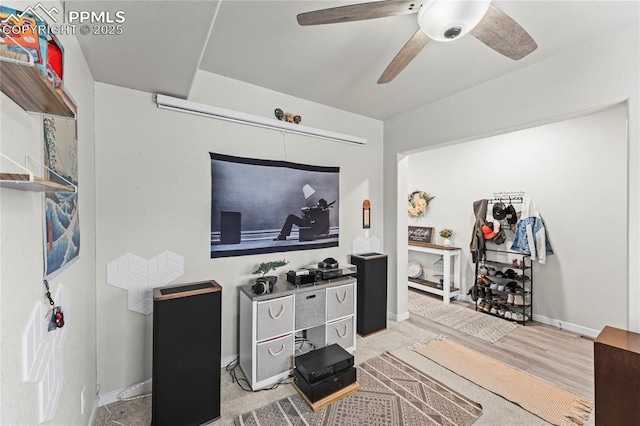 living area featuring baseboards, ceiling fan, and wood finished floors