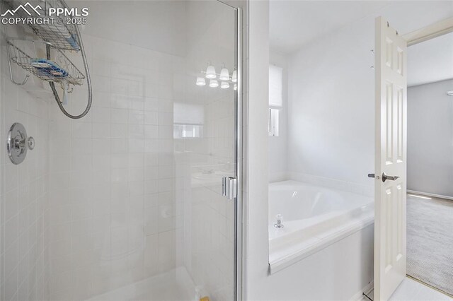 bathroom featuring a bath and a shower stall