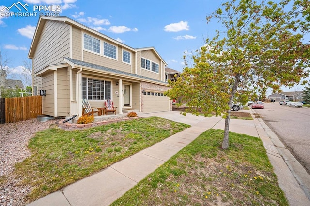 view of front of house featuring a garage, fence, driveway, and covered porch