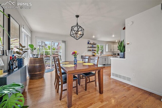 dining space featuring visible vents, recessed lighting, light wood-style floors, and a chandelier