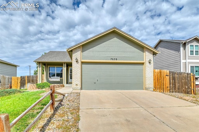 view of front of property featuring fence, an attached garage, brick siding, a front yard, and concrete driveway