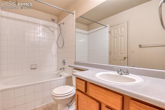 bathroom featuring vanity, washtub / shower combination, tile patterned floors, and toilet