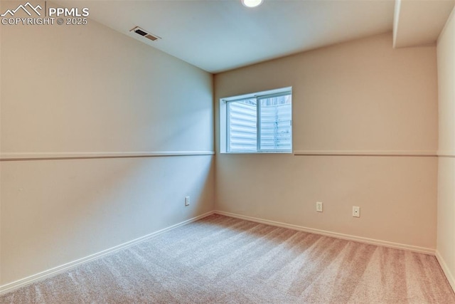 carpeted empty room featuring baseboards and visible vents