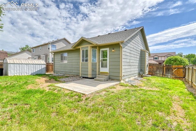 rear view of property featuring entry steps, a patio, a yard, and a fenced backyard