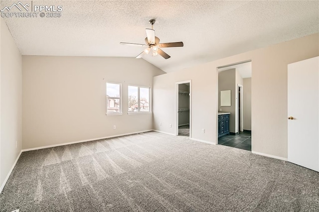 4337 Levi Ln, Colorado Springs, CO 80925 - unfurnished bedroom featuring baseboards, a closet, dark colored carpet, a spacious closet, and lofted ceiling